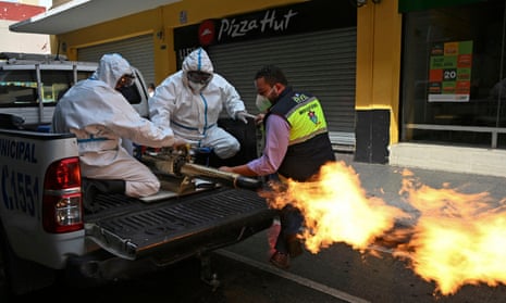 Municipal workers wearing protective gear disinfect the streets in Guatemala City. The pandemic is at its worst moment yet, and discontent is growing.
