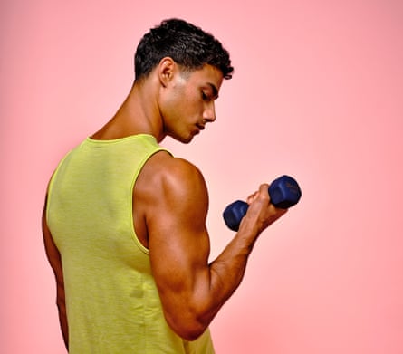 A young man with muscly arms wearing a yellow vest