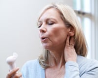 Woman using handheld fan while experiencing hot flush
