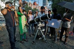 People wear solar filters at a public viewing in Kolkata, India