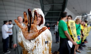 A Greenpeace activist shows her oil-covered hand at the protest outside Total’s annual shareholders’ meeting.