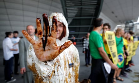 A Greenpeace activist shows her oil-covered hand at the protest outside Total’s annual shareholders’ meeting.