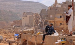 A survivor sits on the rubble of a destroyed building in Libya’s eastern city of Derna.