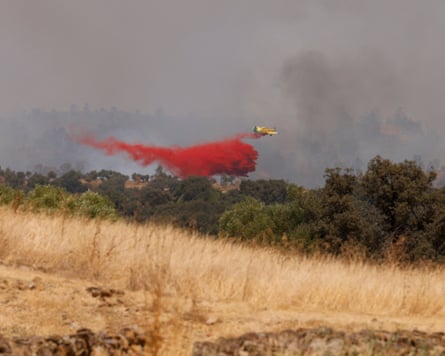 A plane drops retardant over a wildfire