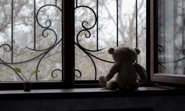 Teddy bear looking out window with bars