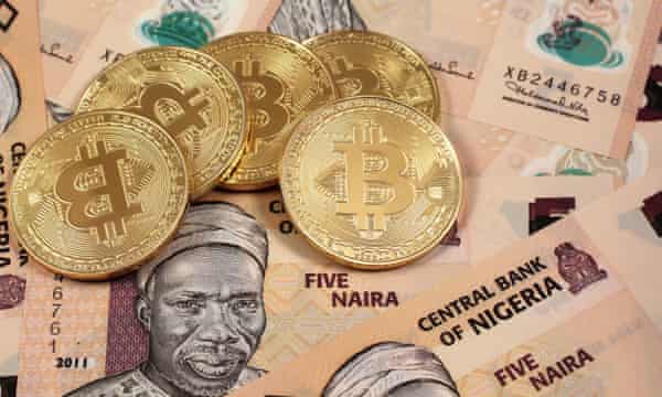 A close up image of golden bitcoins close up with Nigerian naira notes