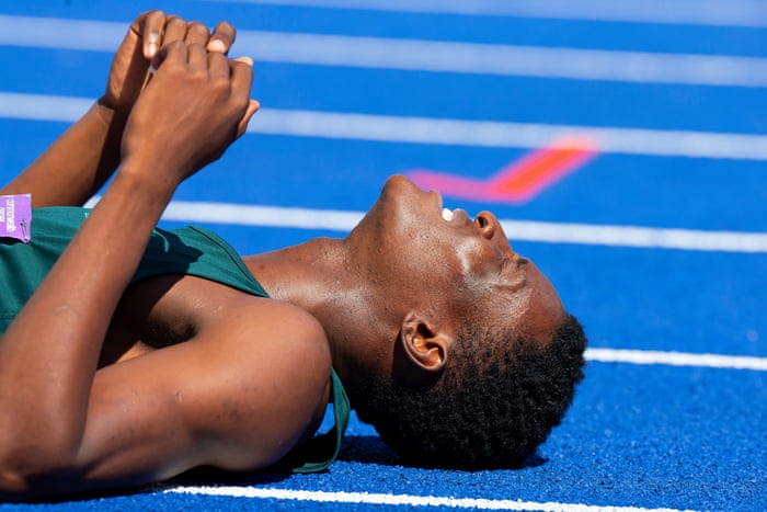 Zambia’s Muzala Samukonga collapses onto the track after winning his men’s 400m heat.
