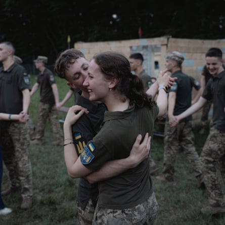 they are casually dressed in short-sleeved khaki shirts with badges on the sleeves and camouflage combat trousers.