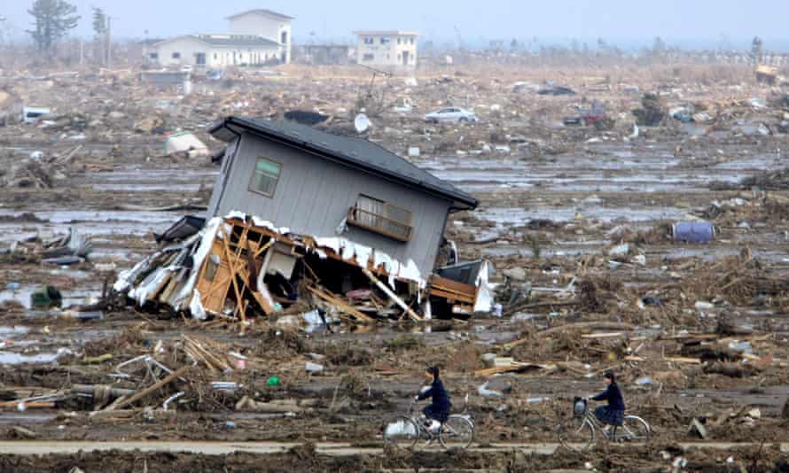 Junior high school students return home amongst rubble on 30 March 2011 in Yamamoto, Miyagi, Japan. 