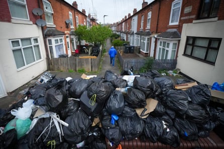 Large pile of black bin bags at the end of a residential street
