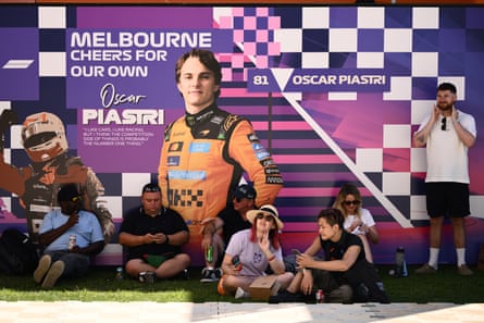 Spectators watch a support race in the grounds in front of a poster supporting local boy Oscar Piastri.
