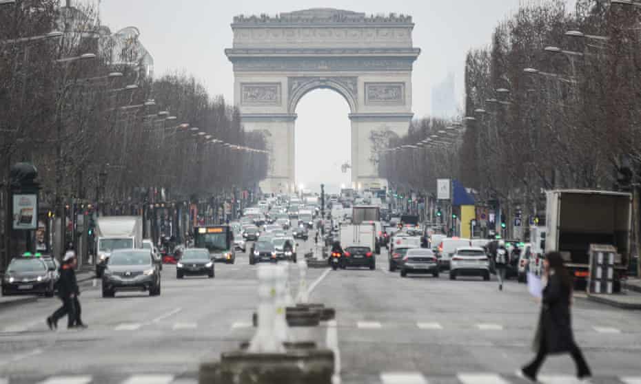Pedestrians walk near the Arc de Triomphe in Paris, France