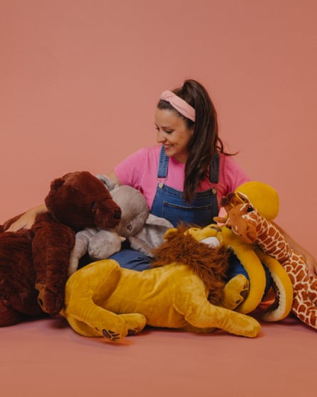 Ms Rachel sitting down surrounded by cuddly toys
