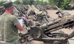 Man in military clothing and many howitzers