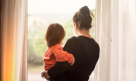 Woman holding toddler looking out of a window