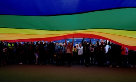 People hold a large rainbow flag during a protest in support of Elzbieta Podlesna who was detained for offending religious beliefs.