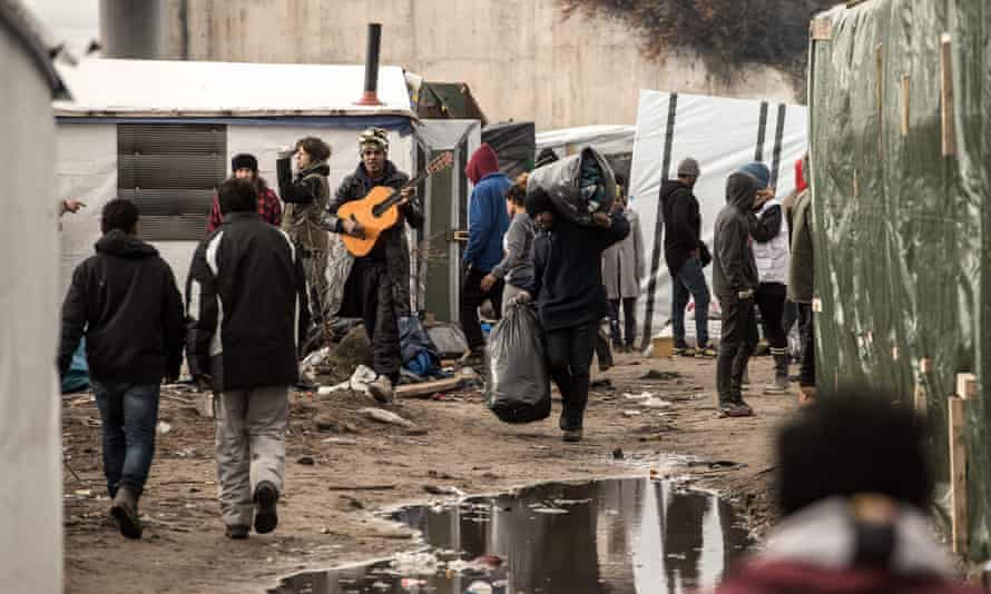 Migrants move their belongings through the camp known as the Jungle in Calais.