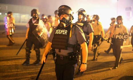 Police advance through a cloud of tear gas toward demonstrators protesting the killing of teenager Michael Brown in Ferguson.