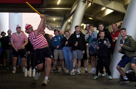Fans enjoy a game of cricket at Old Trafford as they shelter from the rain.