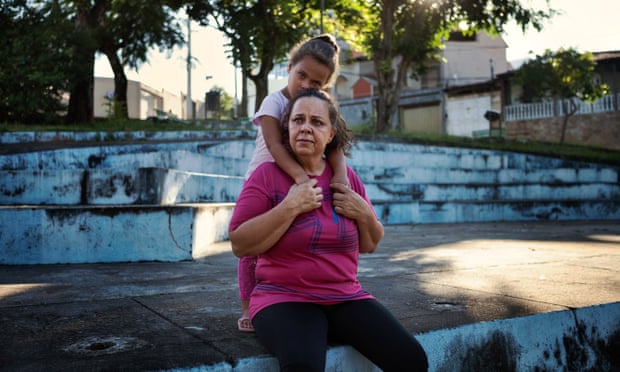 Sandra Quintão, a survivor from Bento Rodrigues, with her daughter in front of a temporary new house in Mariana.