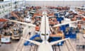 People assemble airplanes inside a warehouse factory
