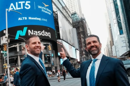 Eric and Donald Trump Jr smile near a Nasdaq display outside