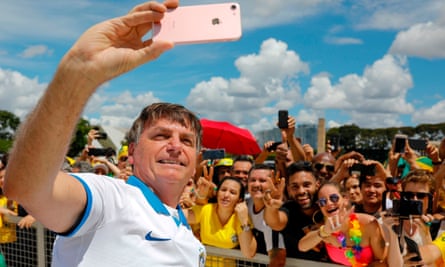 Brazilian President Jair Bolsonaro takes a selfie with supporters after a protest in March 2020.