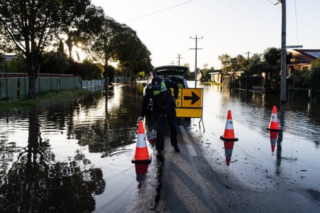 A police officer places a bollard at the start of a flooded road in Shepparton, Victoria on Sunday.