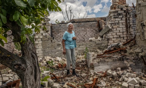 Vira Chernukha with the remains of part of her house behind her.