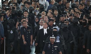 High court judge Azmi Ariffin, third from bottom at centre, arrives with lawyers at the check-in kiosk during the re-enactment.