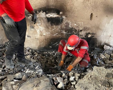 Iranian Red Crescent Society members search through the rubble
