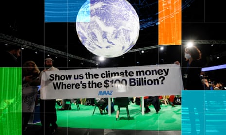 Activists hold a sign that reads: 'Show us the climate money. Where's the $100bn' at Cop26 in Glasgow, Scotland, last year