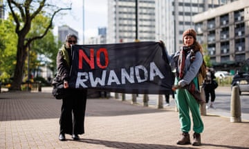 Two people with a banner saying 'No Rwanda'