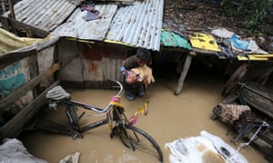 An Indian rag picker carries a child to safety in their Srinigar neighbourhood after it was flooded when the river Jhelum burst its banks in June.