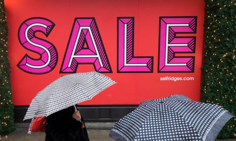 Shoppers visiting the Boxing Day sales during wet and rainy weather in Oxford Street
