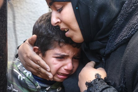 A Palestinian woman and a child on 22 February, following overnight Israeli air strikes in Rafah refugee camp in the southern Gaza Strip.