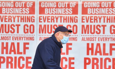 A man walks past a sign in a shop window saying 'going out of business, everything must go' in Stockport