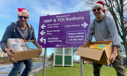 Chris Atkins and Chris Smith delivering books wearing Santa hats.