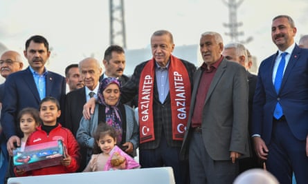 Erdoğan, wearing a red Gaziantep scarf, poses for a photo with Nurdağı residents.