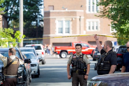 police stands near crime scene tape