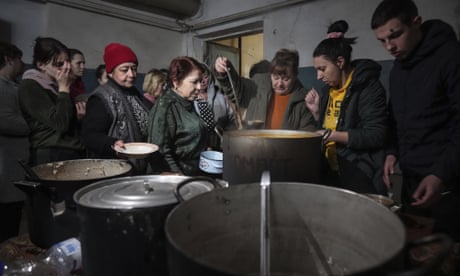 People queue to receive hot food in an improvised bomb shelter in Mariupol, Ukraine, 7 March, 2022.