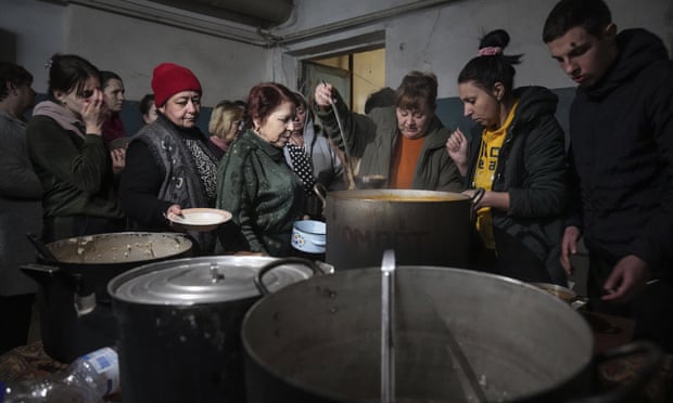 People queue to receive hot food in an improvised bomb shelter in Mariupol, Ukraine, 7 March, 2022. 