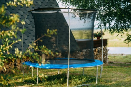 A trampoline in a back yard with a river in the background