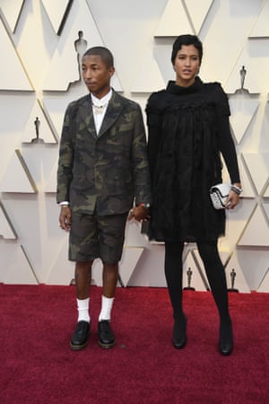 Pharrell Williams arrived with wife Helen Lasichanh. Another homage to Chanel designer Karl Lagerfeld came via Williams' Chanel nameplate necklace, which was probably a last minute addition to his camo shorts suit (an Oscar presenter first). Together the two worked surprisingly well