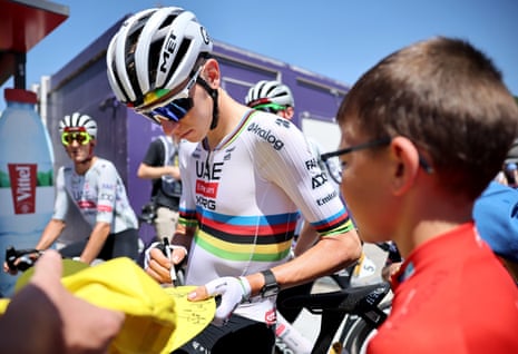 Tadej Pogacar signs autographs before the start of the 11th stage