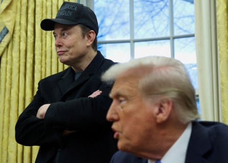 Elon Musk stands behind Donald Trump at the Oval Office on Tuesday.
