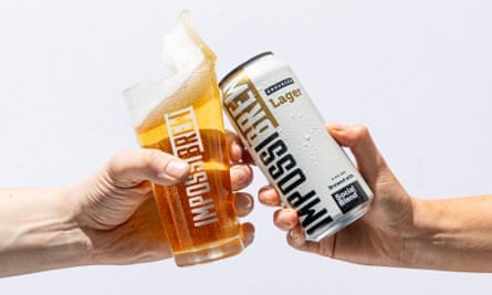 Two hands clinking a glass full and a tin of Impossibrew in centre of image