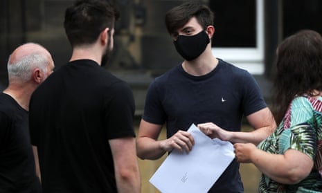 A sixth form student wearing a protective mask opens an envelope containing his A-Level results at Crossley Heath grammar school in Halifax.