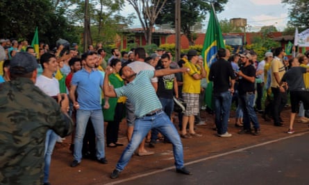 An opponent of the former Brazilian president Luiz Inácio Lula da Silva throws stones during a demonstration.