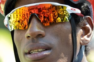 Photographers are reflected in glasses of Eritrea’s Daniel Teklehaimanot, wearing the best climber’s polka dot jersey, as he waits for race to get underway
